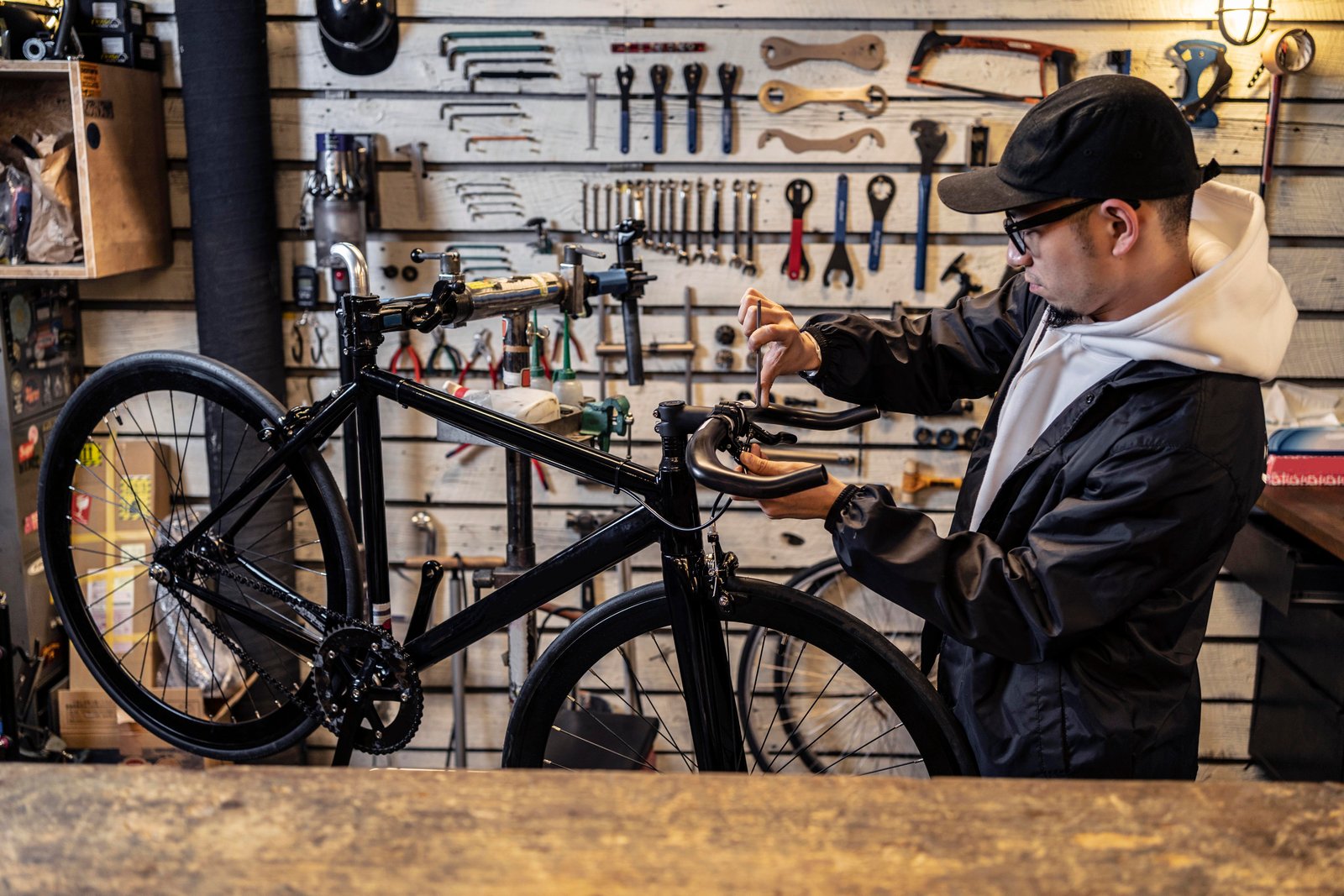Interior of the CycleFix workshop with bicycles on repair stands and tools arranged along the bench